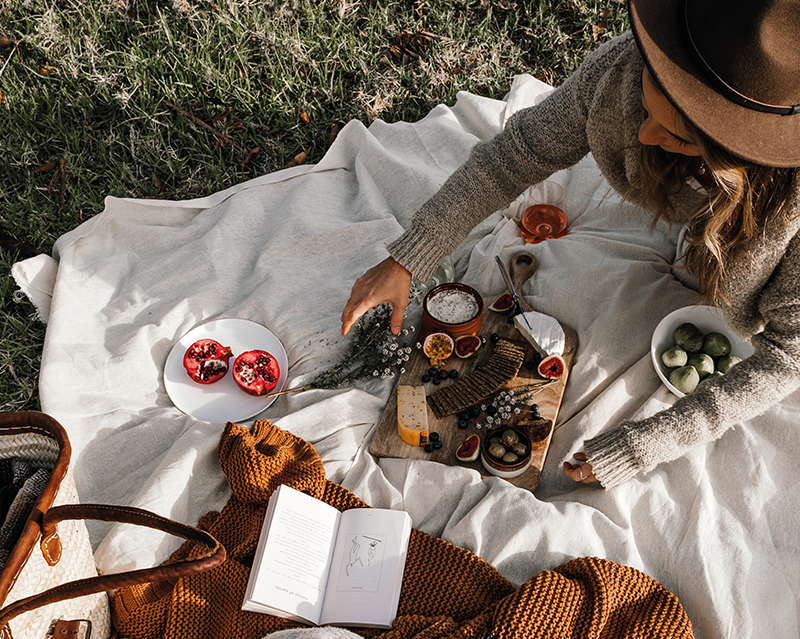 Frau mit Essen auf Picknickdecke