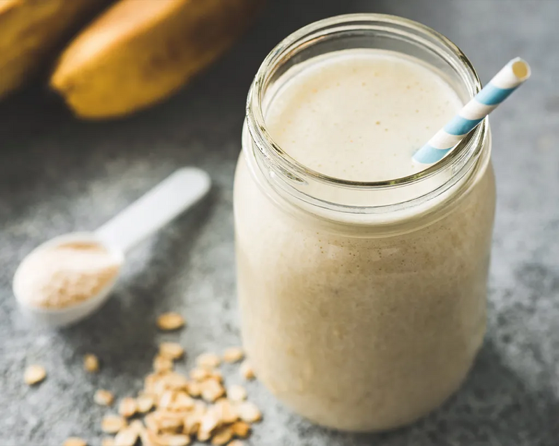 Protein-Shake im Glas mit Trinkhalm