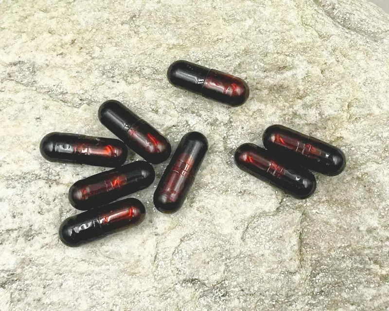 Kapseln mit Astaxanthin auf einem Stein