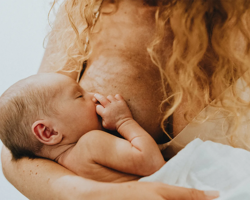 Bild einer Frau, die ihr Baby stillt