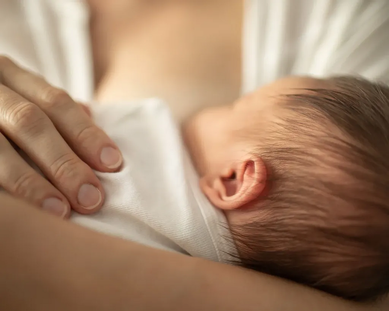 entspannt schlafendes Baby an Mutterbrust